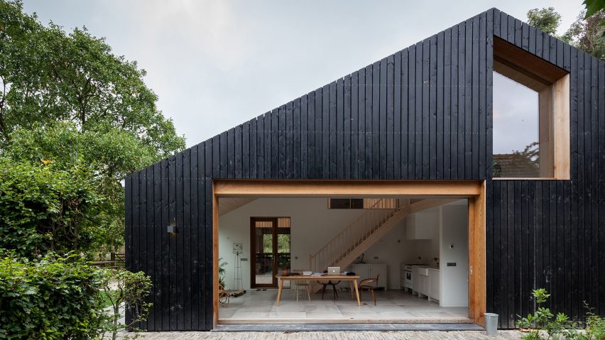 Blackened wood barn by Workshop Architecten houses both livestock and people