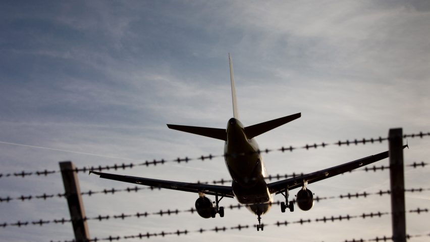 Plane Flying Over Fence