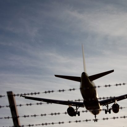 Plane Flying Over Fence