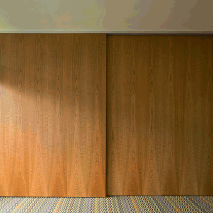 Azman Architects adds cherry-wood partitions and zigzag-patterned carpet to Barbican flat