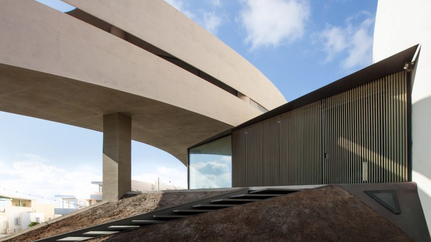 Huge circular hole pierces concrete house in Crete by Tense Architecture Network