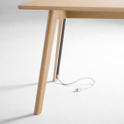 Solem table keeps cables tidy with hidden storage in each leg