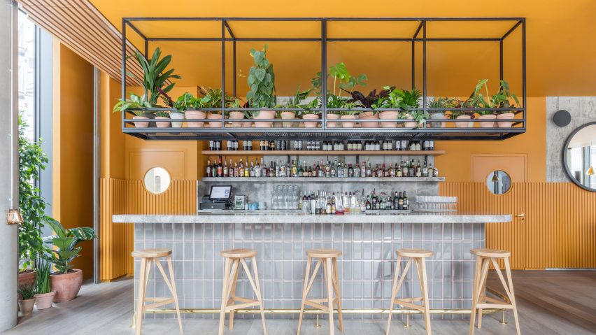 Cement grey meets bright ochre in Grzywinski + Pons’ London restaurant interior