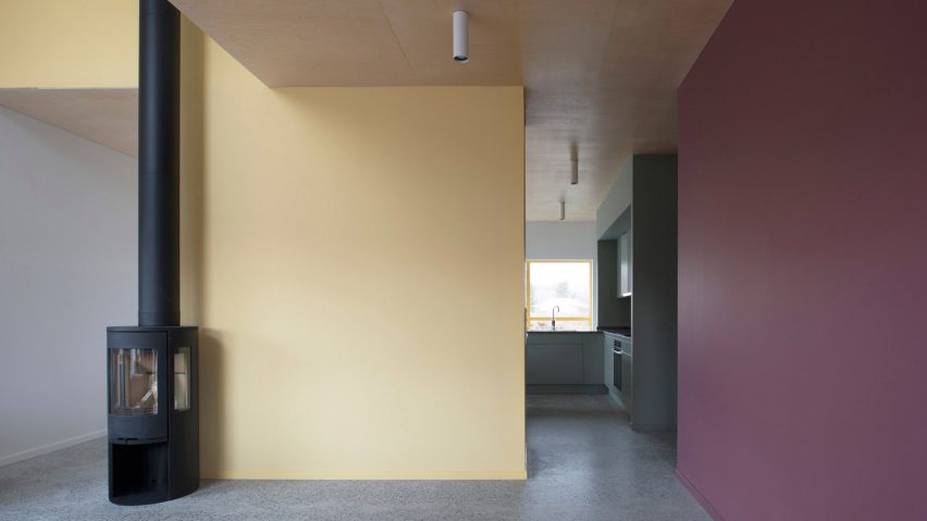 Bright yellow window frames puncture pastel grey walls of Stockholm prefab
