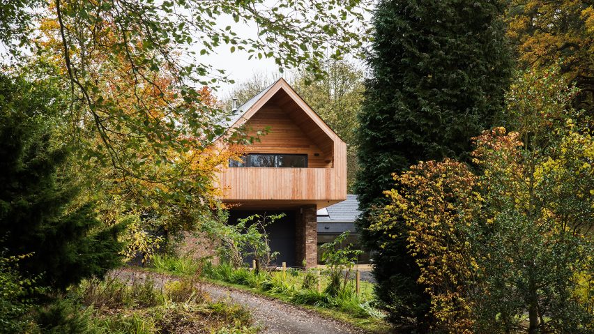 Cross-shaped house by Elliott Architects is adapted to sloping woodland setting