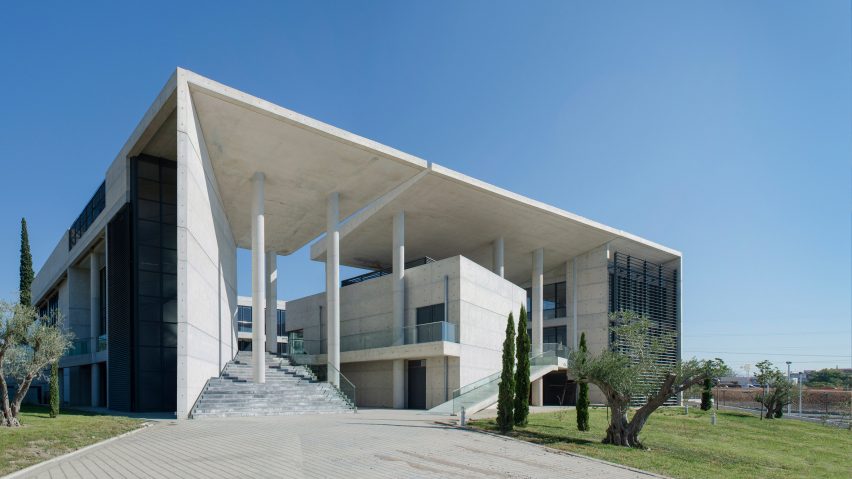 Angled walls and fissures break up mass of concrete office building by Vtria Architects