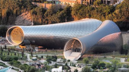 Arial photograph of two conjoined tubular buildings made from metal and glass