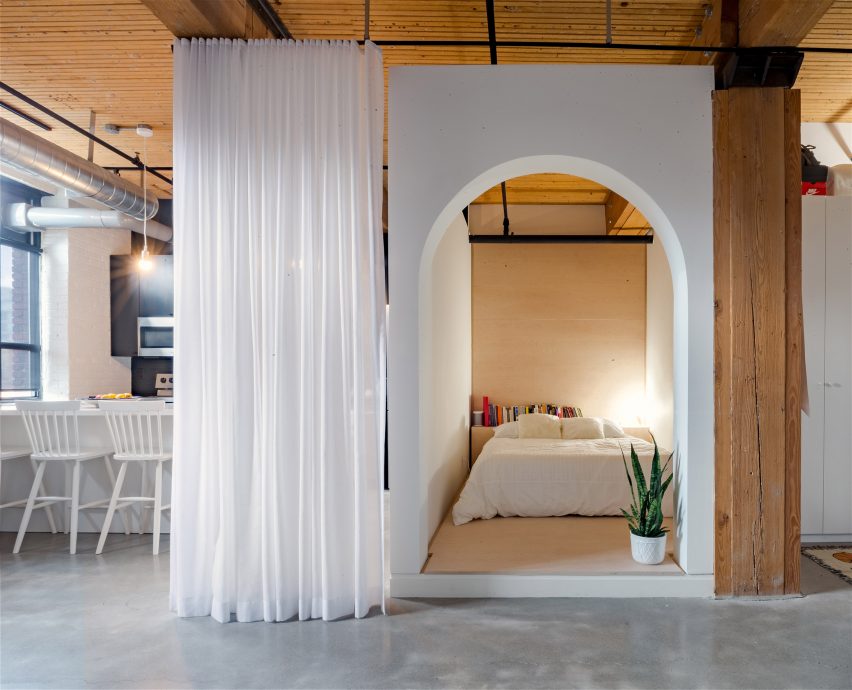 A white curtain in front of a bedroom