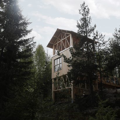 Timber-framed cabin by Hanna Michelson stands on stilts to peep over the treetops of Swedish mountain