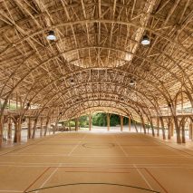 Arched bamboo trusses left exposed in Chiang Mai sports hall to create a “feast to the eye”