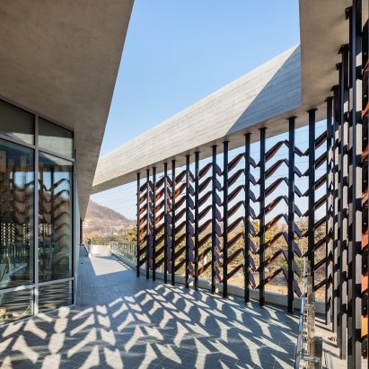 Moveable wooden screens are set into concrete facades of Mokyeonri Wood Culture Museum