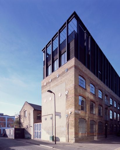 Simon Conder Associates has placed an extension clad in black-stained timber on top of a former warehouse in east London.