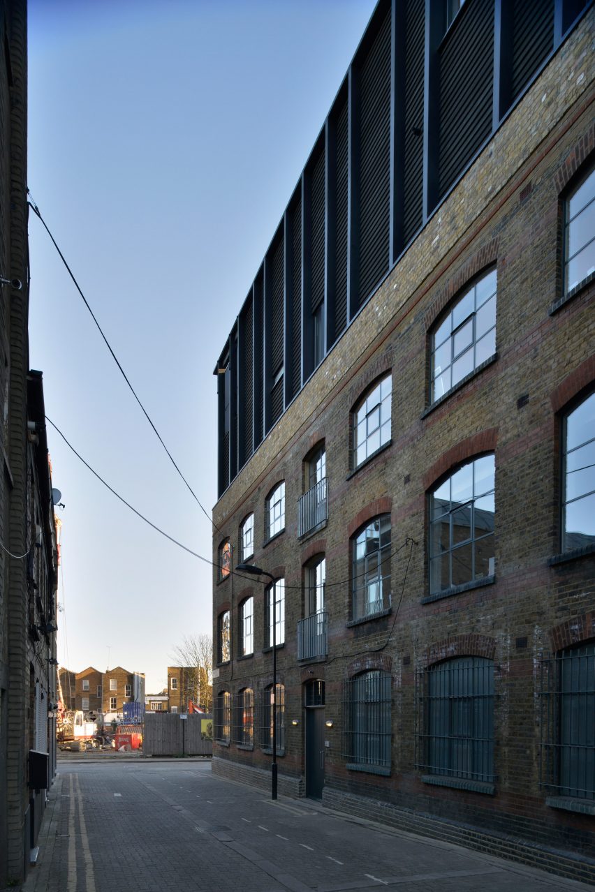 Simon Conder Associates has placed an extension clad in black-stained timber on top of a former warehouse in east London.