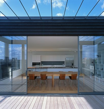 Simon Conder Associates has placed an extension clad in black-stained timber on top of a former warehouse in east London.