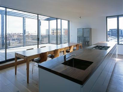 Simon Conder Associates has placed an extension clad in black-stained timber on top of a former warehouse in east London.