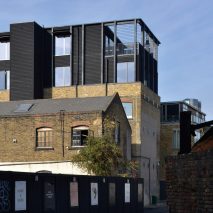 Simon Conder Associates has placed an extension clad in black-stained timber on top of a former warehouse in east London.