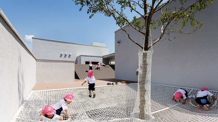 Climbing nets surround tree extending through balcony of Osaka nursery school