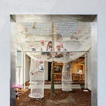 Climbing nets surround tree extending through balcony of Osaka nursery school