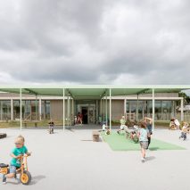 NL Architects completes Belgian school featuring low-lying rooms surrounded by a colonnade.