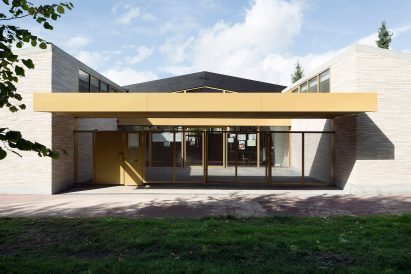 LT2A's brick school extension features porthole-like screens and gold-hued surfaces