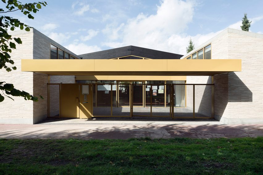 LT2A's brick school extension features porthole-like screens and gold-hued surfaces