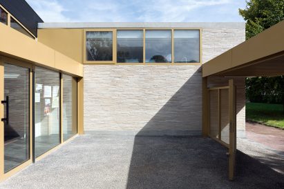 LT2A's brick school extension features porthole-like screens and gold-hued surfaces
