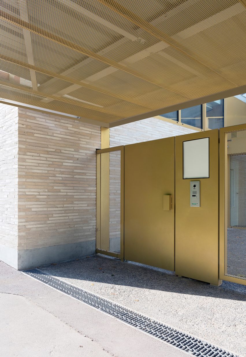 LT2A's brick school extension features porthole-like screens and gold-hued surfaces