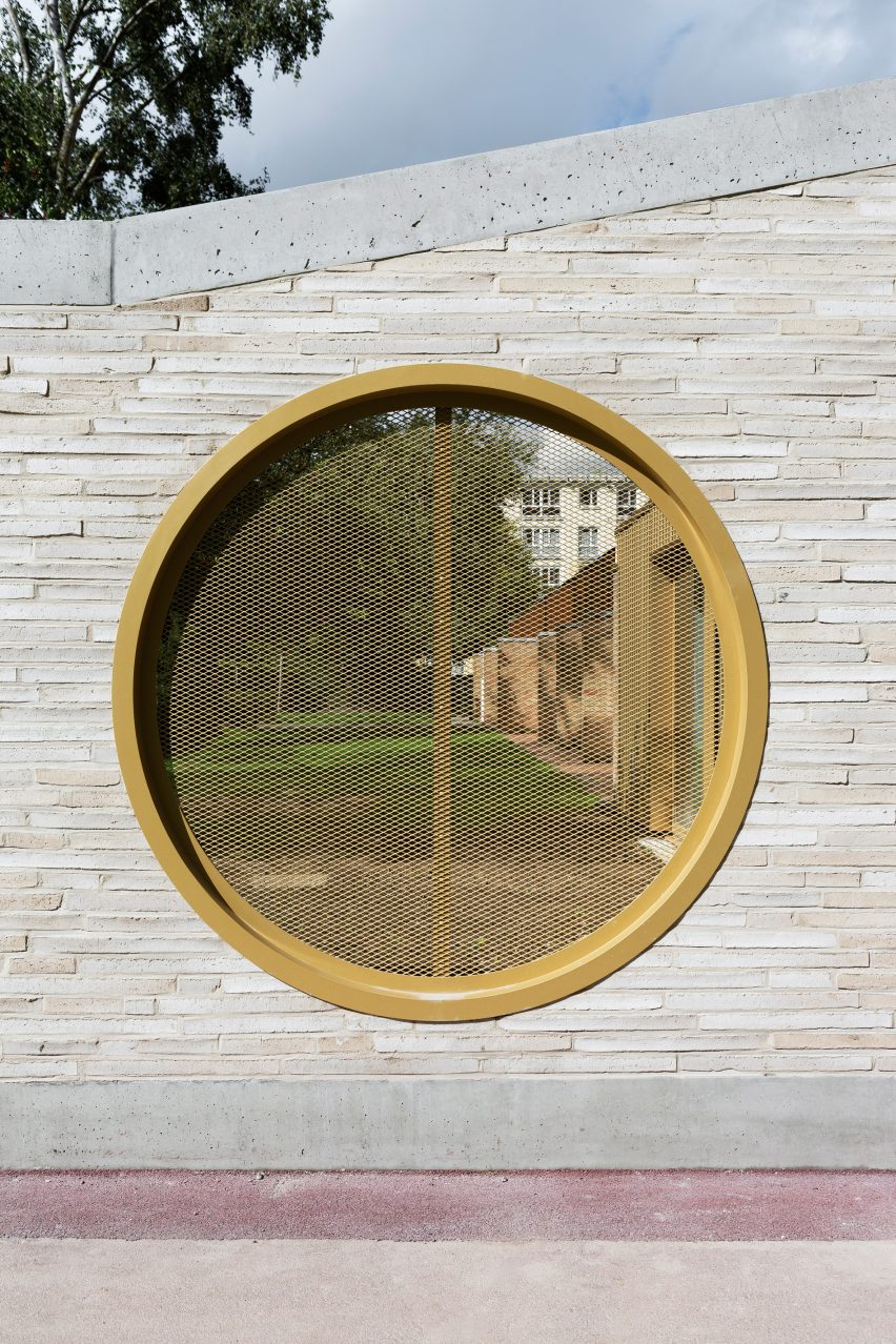 LT2A's brick school extension features porthole-like screens and gold-hued surfaces