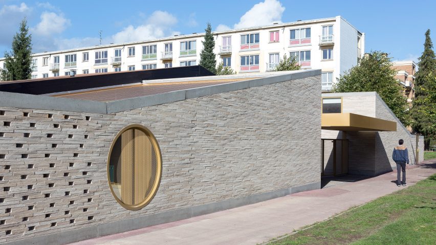 LT2A's brick school extension features porthole-like screens and gold-hued surfaces