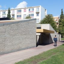 LT2A's brick school extension features porthole-like screens and gold-hued surfaces