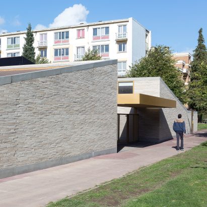 LT2A's brick school extension features porthole-like screens and gold-hued surfaces