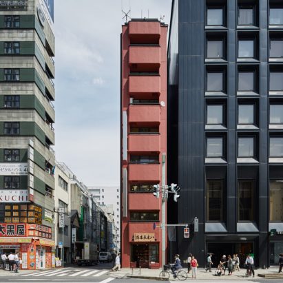 Schemata Architects creates red-toned interior for Tokyo grocery store inside skinny tower
