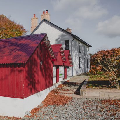 Rural Office for Architecture adds row of red gabled sheds to rural Welsh property