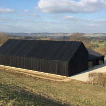 Black-stained barn built by Macdonald Wright Architects at Caring Wood country house