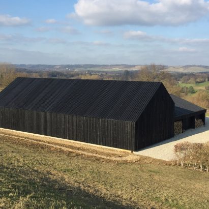 Black-stained barn built by Macdonald Wright Architects at Caring Wood country house