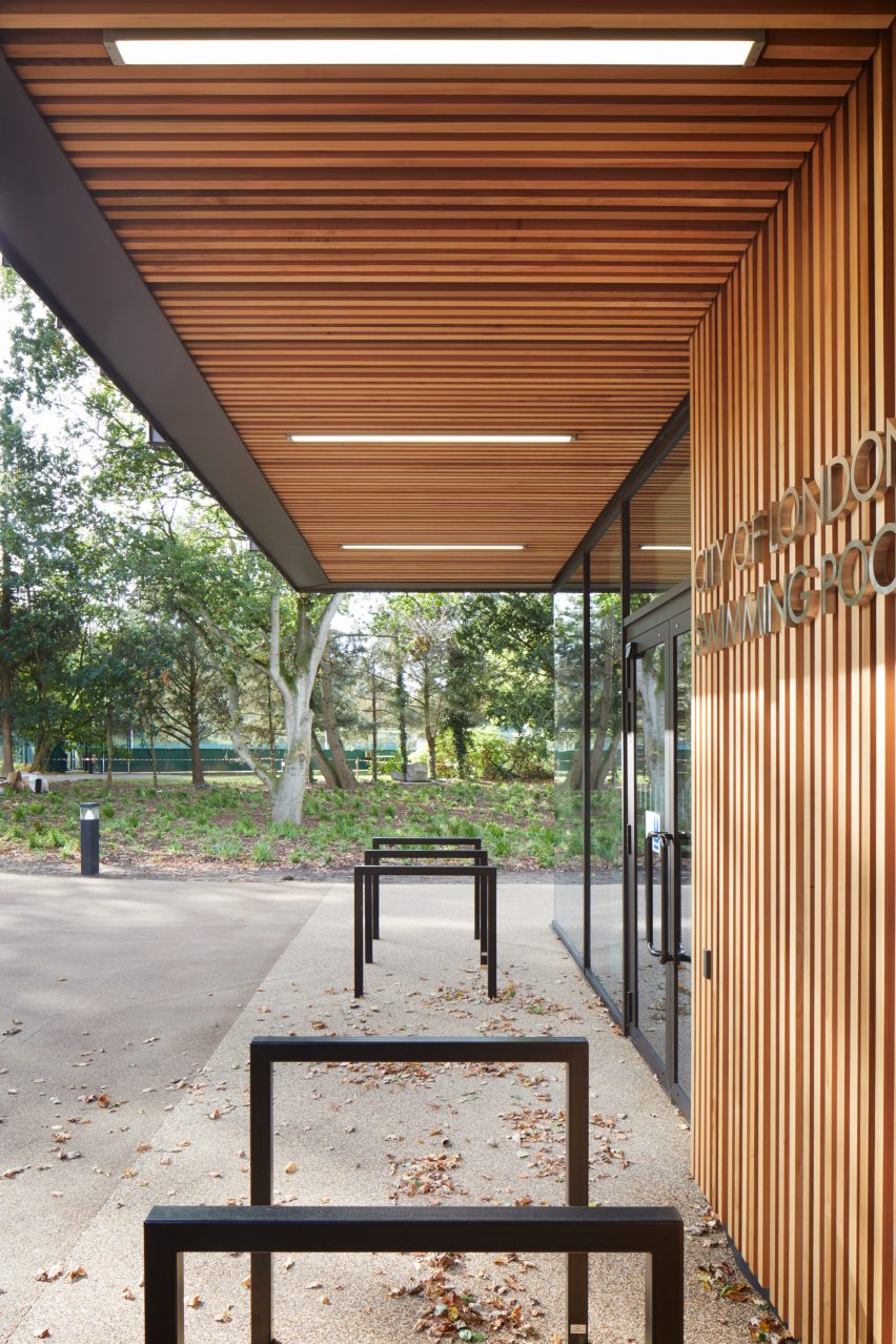 British firm Hawkins\Brown has completed a swimming-pool building at a school in Surrey, England, featuring an exposed timber frame that incorporates windows looking out onto the surrounding woodland.