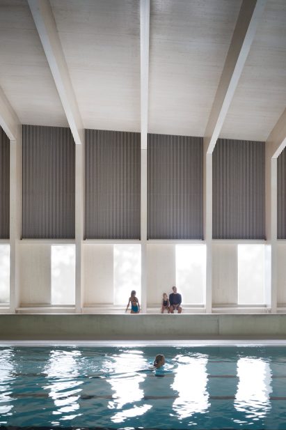 British firm Hawkins\Brown has completed a swimming-pool building at a school in Surrey, England, featuring an exposed timber frame that incorporates windows looking out onto the surrounding woodland.