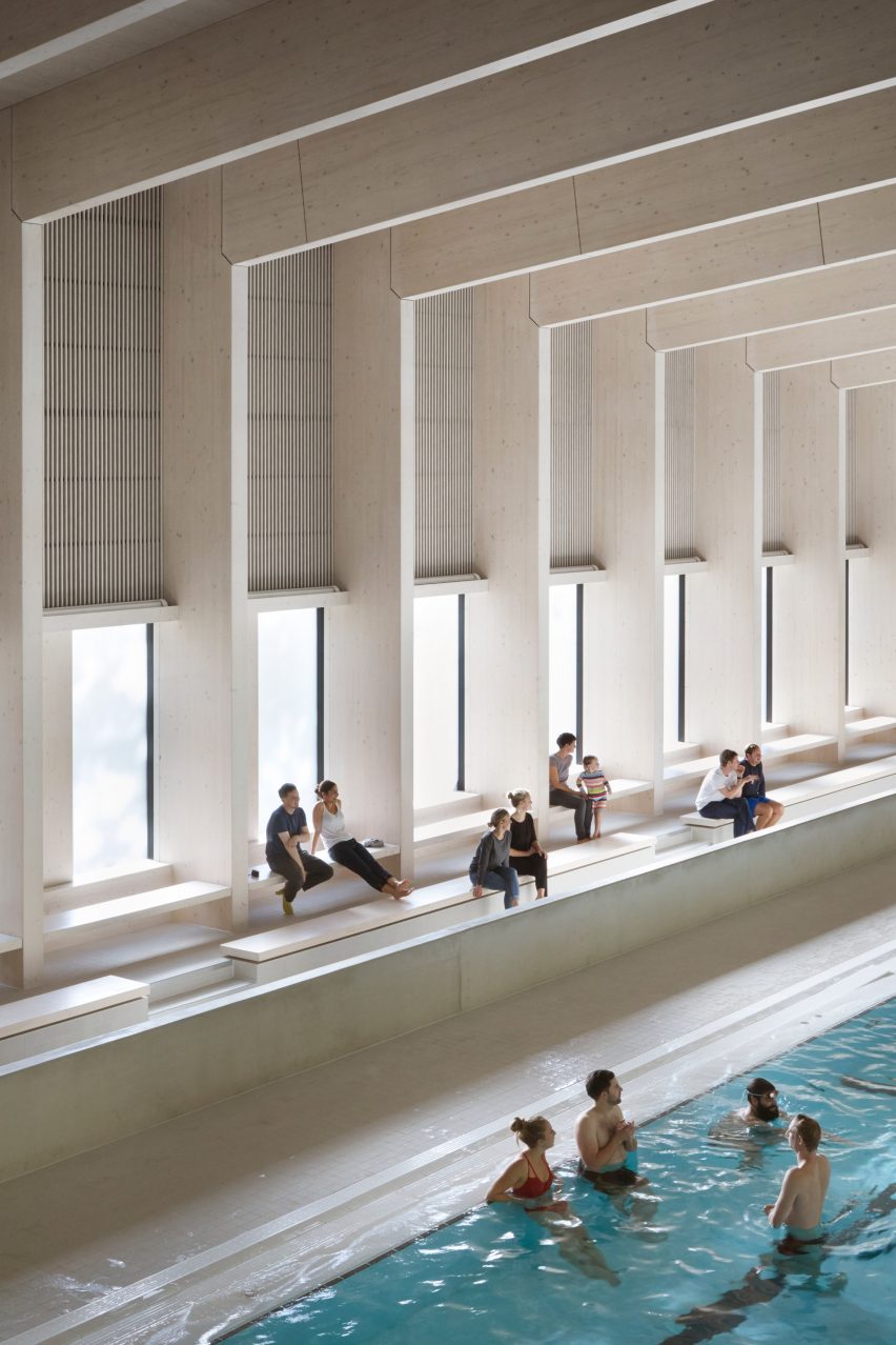 British firm Hawkins\Brown has completed a swimming-pool building at a school in Surrey, England, featuring an exposed timber frame that incorporates windows looking out onto the surrounding woodland.