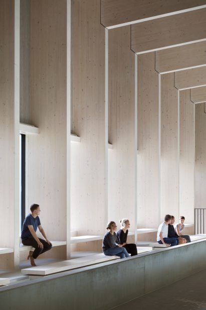 British firm Hawkins\Brown has completed a swimming-pool building at a school in Surrey, England, featuring an exposed timber frame that incorporates windows looking out onto the surrounding woodland.