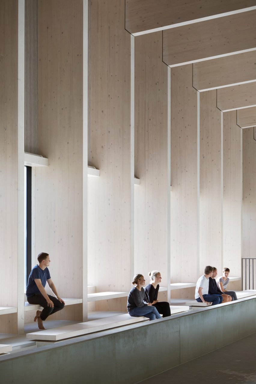 British firm Hawkins\Brown has completed a swimming-pool building at a school in Surrey, England, featuring an exposed timber frame that incorporates windows looking out onto the surrounding woodland.