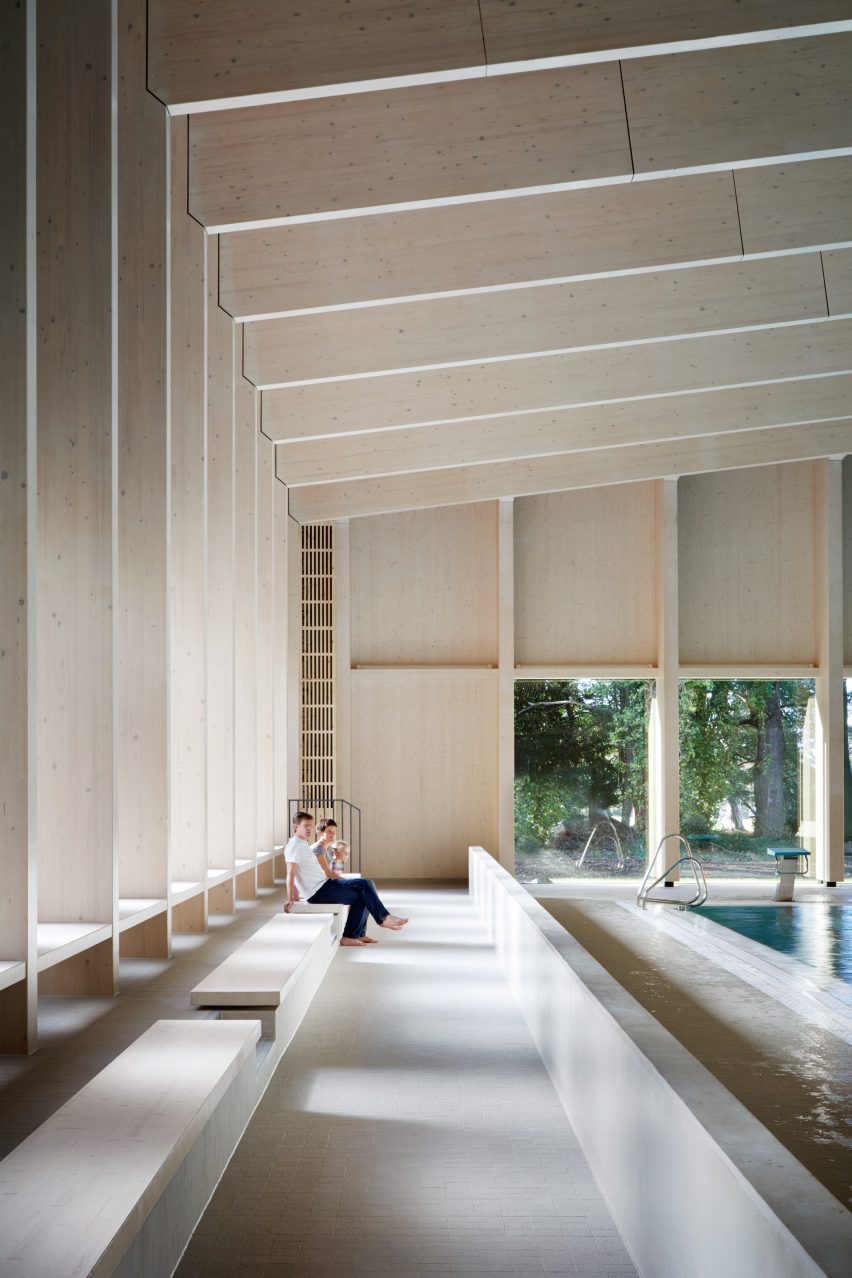 British firm Hawkins\Brown has completed a swimming-pool building at a school in Surrey, England, featuring an exposed timber frame that incorporates windows looking out onto the surrounding woodland.