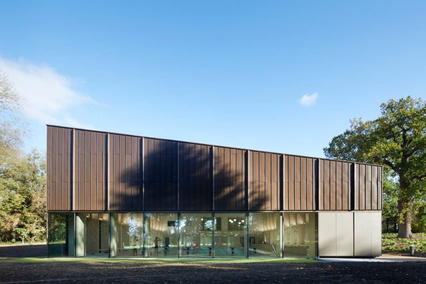 British firm Hawkins\Brown has completed a swimming-pool building at a school in Surrey, England, featuring an exposed timber frame that incorporates windows looking out onto the surrounding woodland.