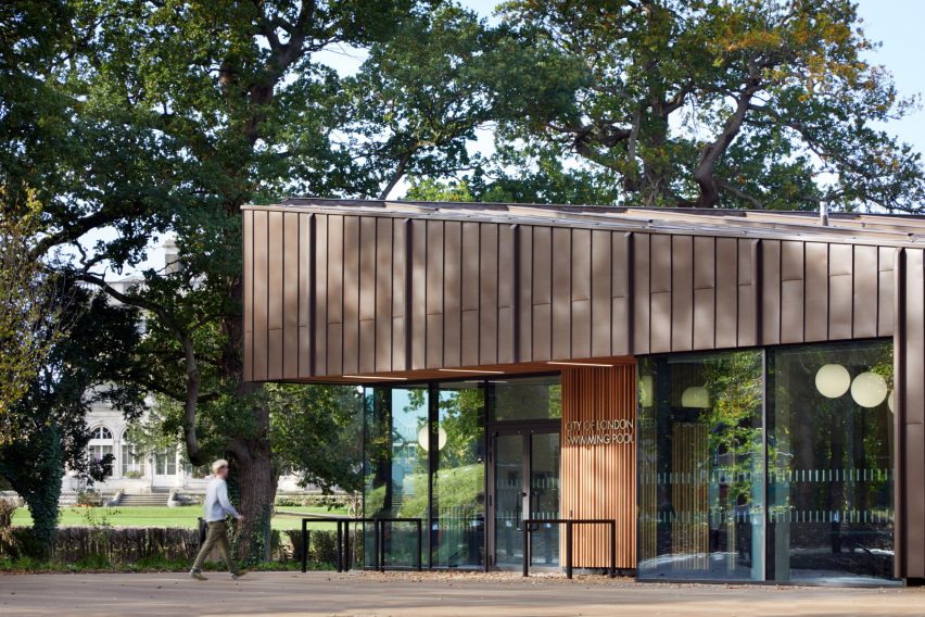 British firm Hawkins\Brown has completed a swimming-pool building at a school in Surrey, England, featuring an exposed timber frame that incorporates windows looking out onto the surrounding woodland.