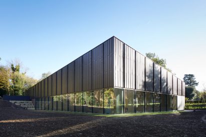 British firm Hawkins\Brown has completed a swimming-pool building at a school in Surrey, England, featuring an exposed timber frame that incorporates windows looking out onto the surrounding woodland.