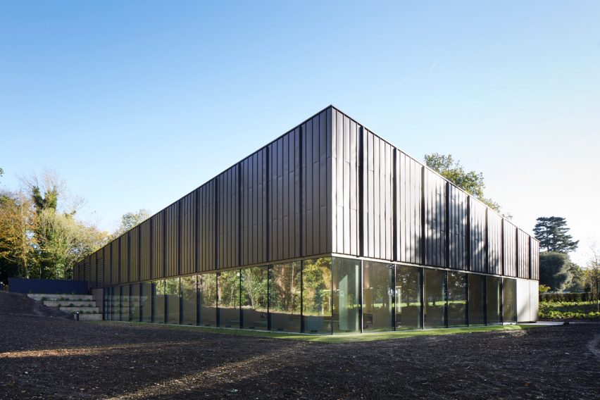 British firm Hawkins\Brown has completed a swimming-pool building at a school in Surrey, England, featuring an exposed timber frame that incorporates windows looking out onto the surrounding woodland.