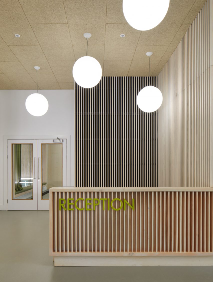 British firm Hawkins\Brown has completed a swimming-pool building at a school in Surrey, England, featuring an exposed timber frame that incorporates windows looking out onto the surrounding woodland.