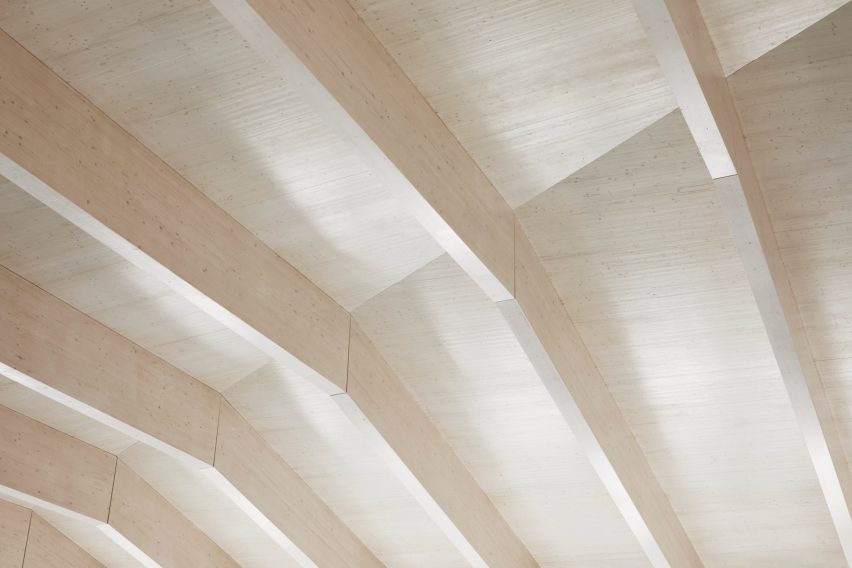 British firm Hawkins\Brown has completed a swimming-pool building at a school in Surrey, England, featuring an exposed timber frame that incorporates windows looking out onto the surrounding woodland.
