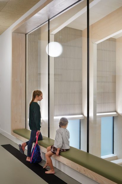 British firm Hawkins\Brown has completed a swimming-pool building at a school in Surrey, England, featuring an exposed timber frame that incorporates windows looking out onto the surrounding woodland.