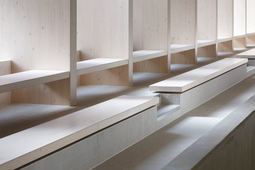 British firm Hawkins\Brown has completed a swimming-pool building at a school in Surrey, England, featuring an exposed timber frame that incorporates windows looking out onto the surrounding woodland.