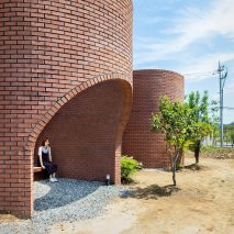 The Vault House by OBBA incorporates hidden gardens behind curving brick walls
